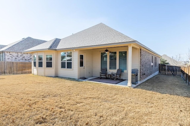 rear view of property featuring a yard, a patio area, and ceiling fan