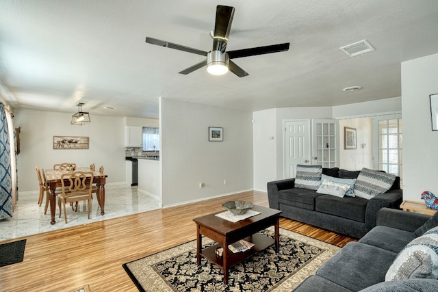 living room with ceiling fan and light wood-type flooring