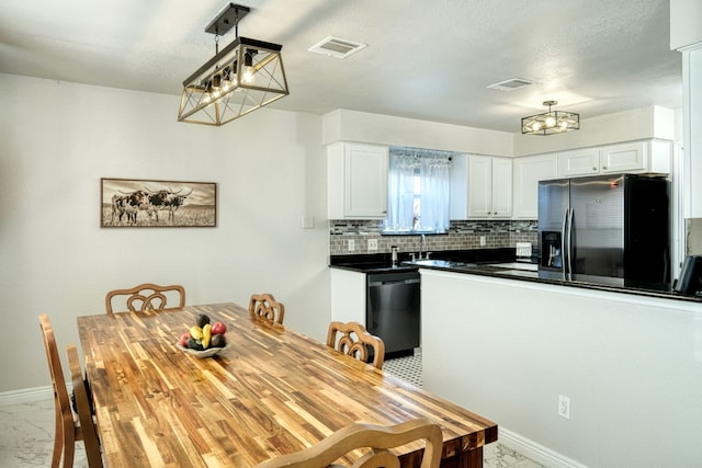 kitchen with stainless steel refrigerator with ice dispenser, white cabinetry, decorative light fixtures, dishwasher, and backsplash