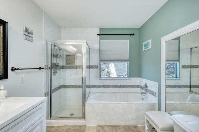 bathroom with vanity and shower with separate bathtub