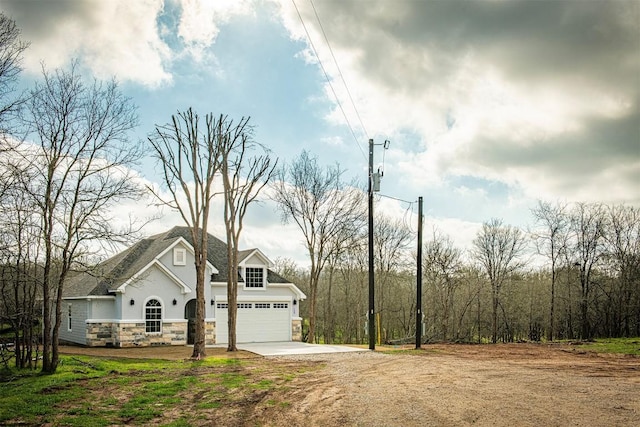 130 E Keomuku Ln, Bastrop, TX 78602 - view of front of property with stone siding, driveway, and stucco siding