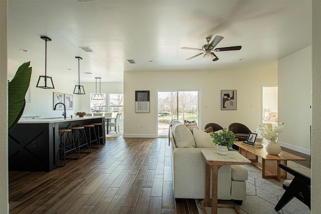 130 E Keomuku Ln, Bastrop, TX 78602 - living room featuring dark wood-type flooring, a ceiling fan, and baseboards