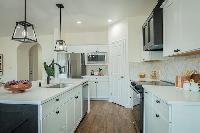 kitchen featuring stainless steel appliances, white cabinetry, sink, and pendant lighting