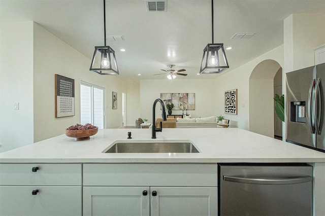 130 E Keomuku Ln, Bastrop, TX 78602 - kitchen featuring appliances with stainless steel finishes, a sink, open floor plan, light countertops, and arched walkways