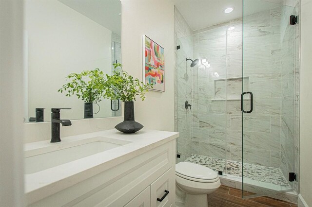 130 E Keomuku Ln, Bastrop, TX 78602 - full bath featuring vanity, a shower stall, toilet, wood finished floors, and recessed lighting