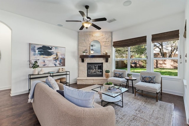 living room with a fireplace, dark wood-type flooring, and ceiling fan