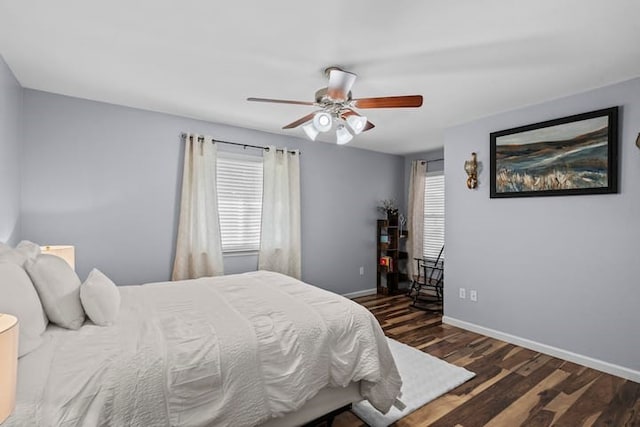 bedroom with multiple windows, ceiling fan, and dark hardwood / wood-style flooring