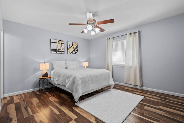 bedroom with dark hardwood / wood-style flooring and ceiling fan