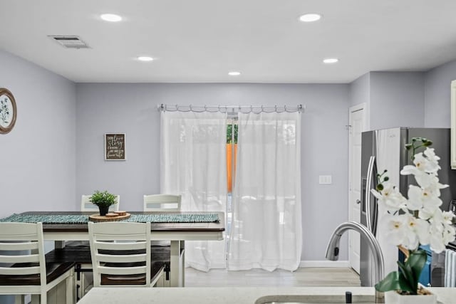 dining space with sink and light hardwood / wood-style floors