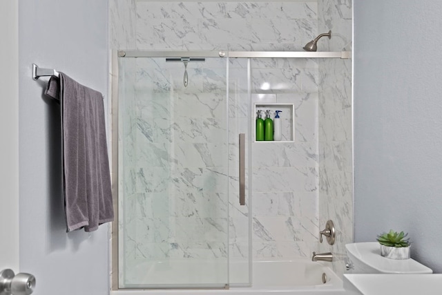 bathroom featuring shower / bath combination with glass door and toilet