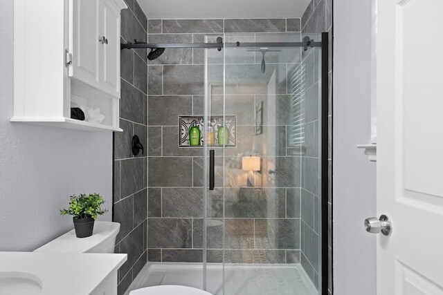 bathroom with vanity, toilet, and a shower with shower door