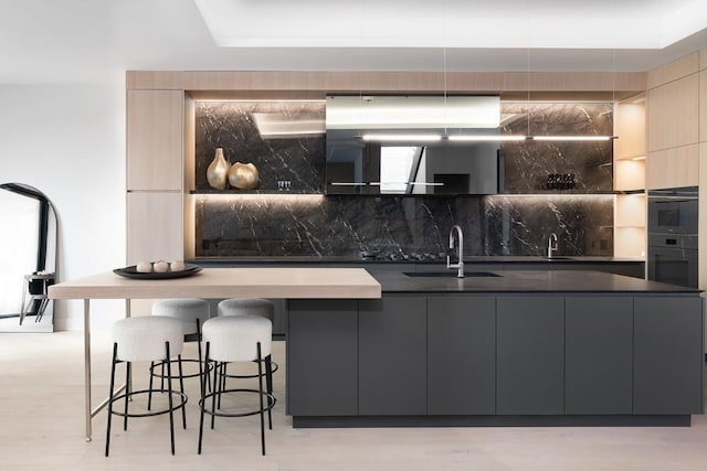 kitchen with a sink, black oven, decorative backsplash, dark countertops, and modern cabinets