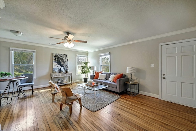 living room featuring hardwood / wood-style flooring, ornamental molding, and a healthy amount of sunlight