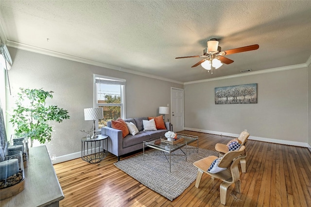 living room with ornamental molding, hardwood / wood-style floors, ceiling fan, and a textured ceiling