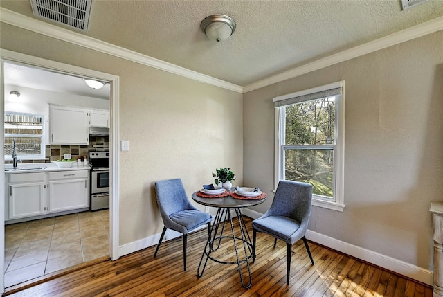 2201 Indian Creek Rd, Austin, TX 78734 - dining space with crown molding, baseboards, wood-type flooring, and a textured ceiling