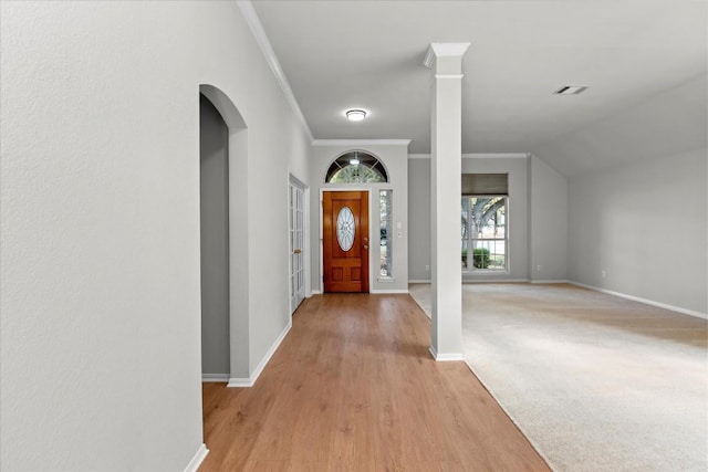 carpeted foyer entrance featuring crown molding