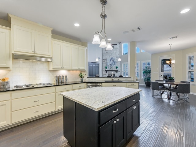 kitchen with backsplash, hanging light fixtures, a center island, kitchen peninsula, and an inviting chandelier