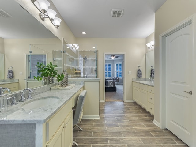 bathroom with ceiling fan, vanity, and a shower with door