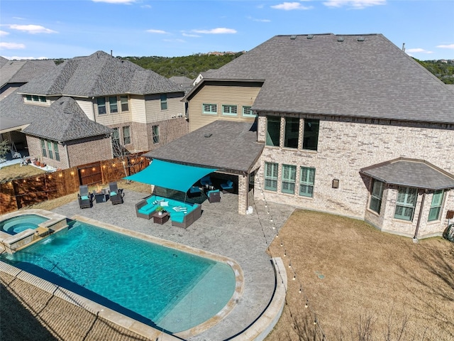 view of swimming pool with a patio, outdoor lounge area, an in ground hot tub, pool water feature, and a yard