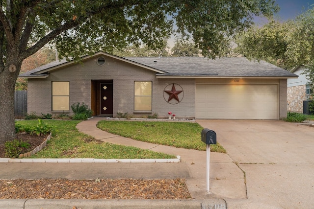 ranch-style house featuring a garage and a yard