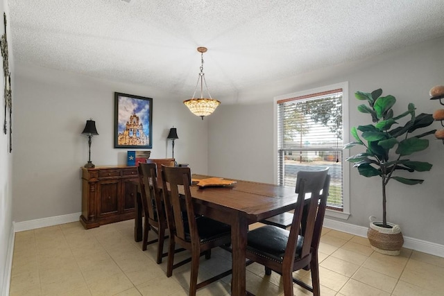 dining area featuring light tile patterned floors and a textured ceiling