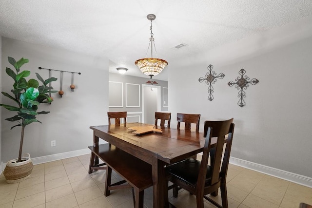 dining room featuring a textured ceiling and light tile patterned floors