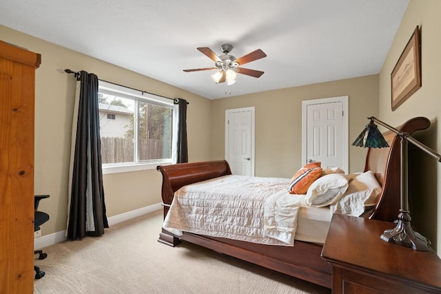 bedroom with two closets, light colored carpet, and ceiling fan