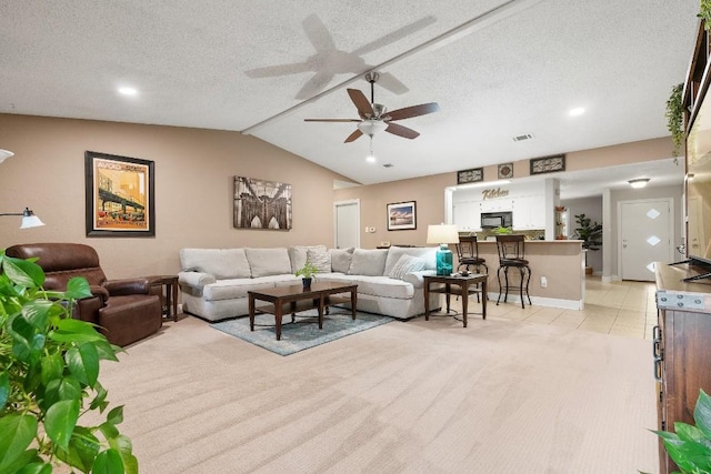 tiled living room featuring lofted ceiling, ceiling fan, and a textured ceiling