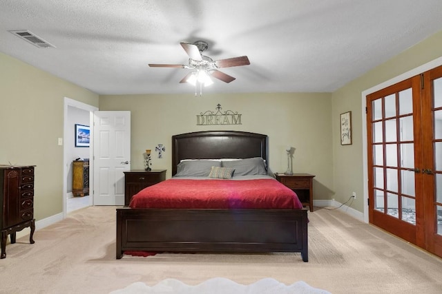 bedroom featuring ceiling fan, light colored carpet, a textured ceiling, and french doors