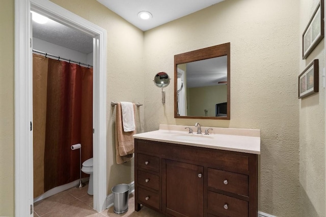 bathroom featuring tile patterned flooring, vanity, and toilet