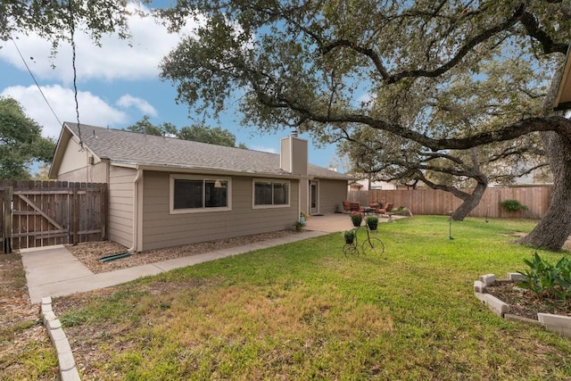 rear view of house with a patio and a yard