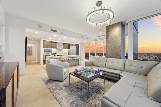 living room with expansive windows and light hardwood / wood-style floors