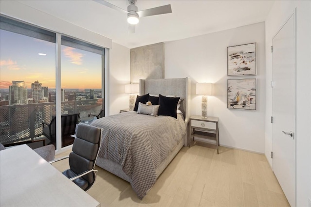 bedroom featuring ceiling fan, access to exterior, and light hardwood / wood-style flooring