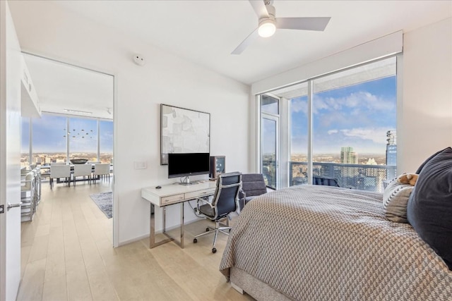 bedroom with expansive windows, ceiling fan, access to exterior, and light hardwood / wood-style floors