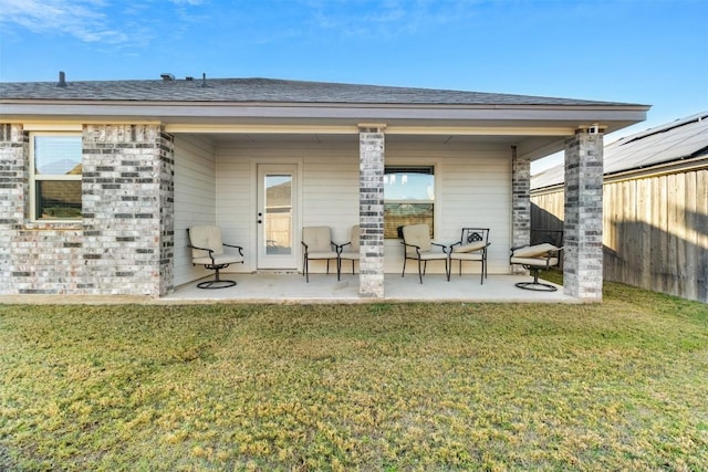 rear view of house featuring a lawn and a patio