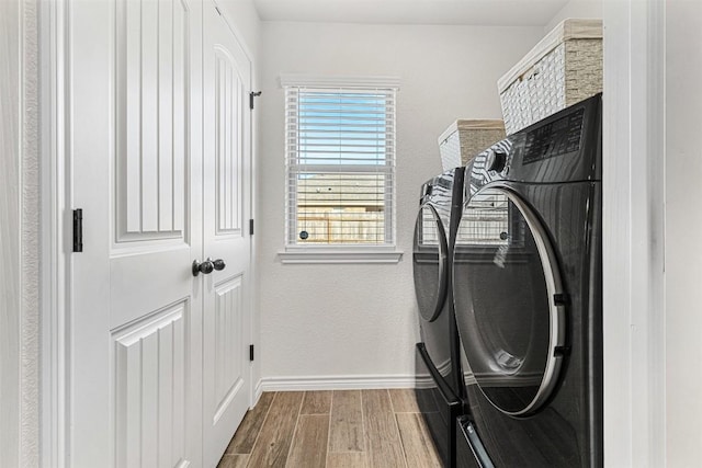 laundry room with hardwood / wood-style flooring and separate washer and dryer