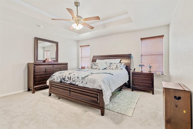 bedroom featuring ceiling fan, light colored carpet, ornamental molding, and a raised ceiling