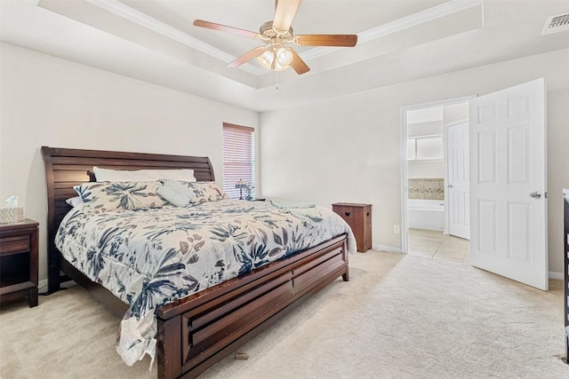 bedroom featuring ensuite bathroom, light carpet, ornamental molding, a raised ceiling, and ceiling fan