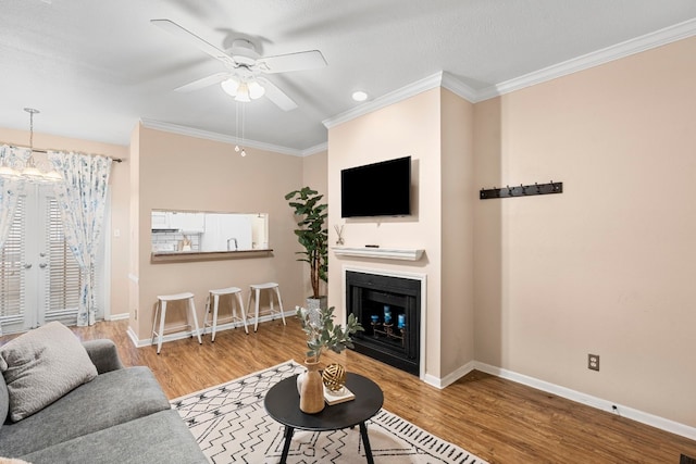 living room featuring crown molding, ceiling fan, light hardwood / wood-style floors, and french doors