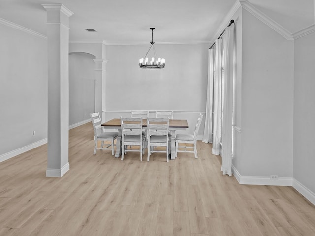 dining area featuring a notable chandelier, crown molding, light hardwood / wood-style flooring, and decorative columns