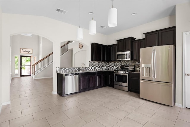 kitchen featuring light tile patterned flooring, pendant lighting, sink, decorative backsplash, and stainless steel appliances