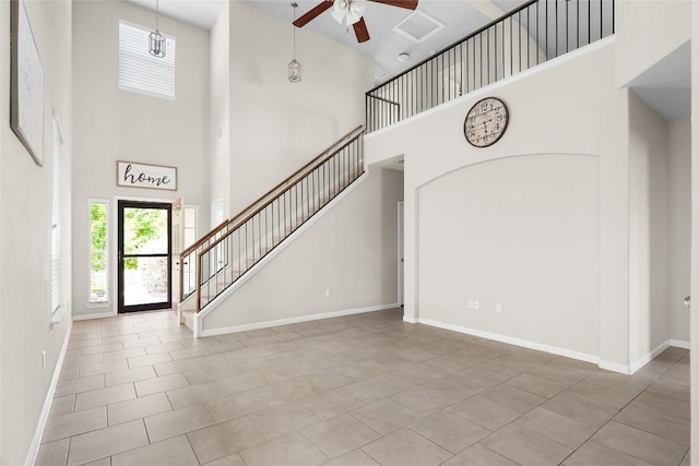 entryway featuring ceiling fan and a towering ceiling