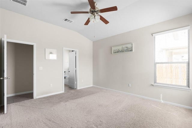 unfurnished bedroom featuring lofted ceiling, light carpet, connected bathroom, and ceiling fan