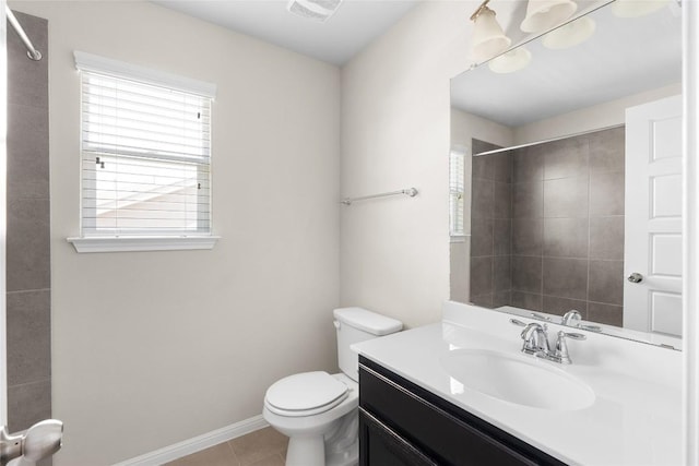 bathroom featuring vanity, plenty of natural light, tile patterned floors, and toilet