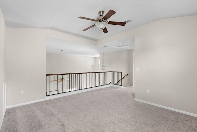 carpeted spare room featuring vaulted ceiling and ceiling fan