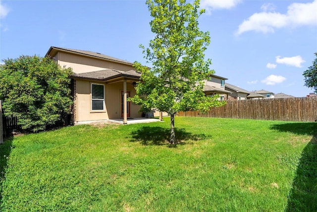 rear view of house featuring a yard and a patio