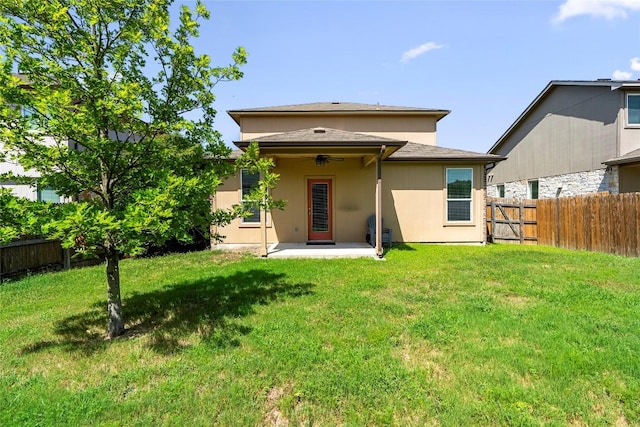 rear view of house featuring fence, a patio, a ceiling fan, stucco siding, and a yard