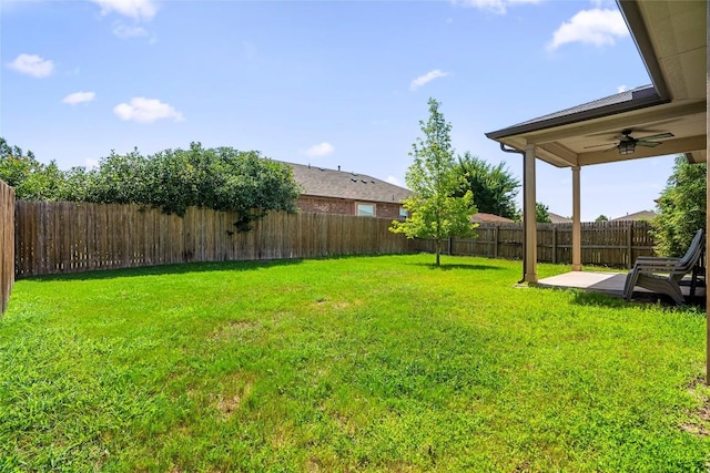 view of yard with a fenced backyard, a ceiling fan, and a patio