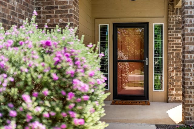 view of exterior entry with brick siding