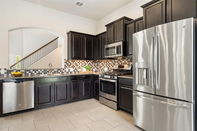 kitchen with a sink, visible vents, stainless steel appliances, and backsplash